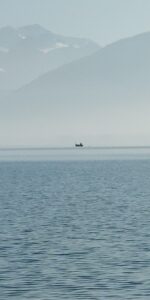 Petite barque isolée sur le lac d’Annecy noyé dans la brume.
