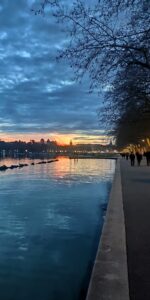 Eau bleue et reflets orangés le long des quais du lac d’Annecy.